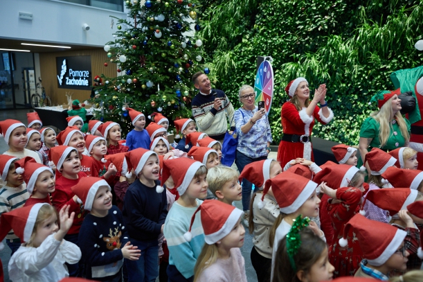 Wspólnie z marszałkiem Olgierdem Geblewiczem przedszkolaki wypatrują Mikołaja, który pojawił się na ostatnim pietrze urzędu