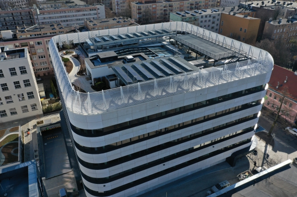 Widok z lotu ptaka na budynek pasywny w tym na dach obiektu,  gdzie zamontowane są panele fotowoltaiczne pełniące funkcję małej ekologicznej elektrowni słonecznej