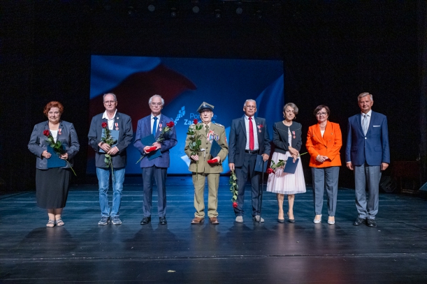 Spotkanie z kombatantami i opozycjionistami w Teatrze Polskim w Szczecinie. Na scenie Przewodnicząca Sejmiku Teresa Kalina, Członek Zarządu Województwa Stanisław Wziątek, dwie uhonorowane odznakami kobiety i czterech mężczyzn (jeden w mundurze).