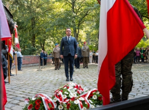 Członek  Zarządu Województwa podchodzi pod Pomnik Sybiraków na Cmentarzu Centralnym w Szczecinie, by złożyć wieniec. 